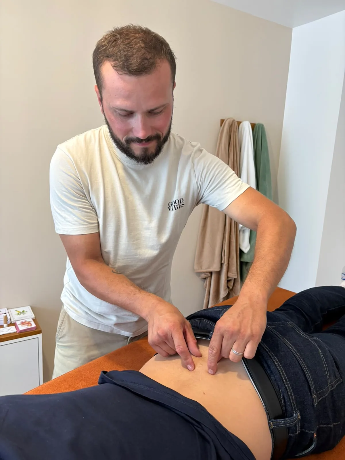 Pratique manuelle douce au niveau de l’abdomen pendant une séance.